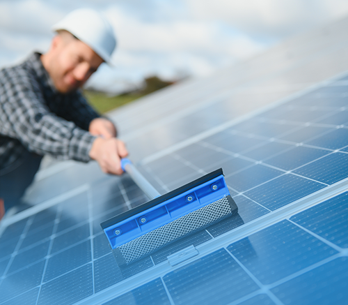 Cleaning solar panels with squeegee